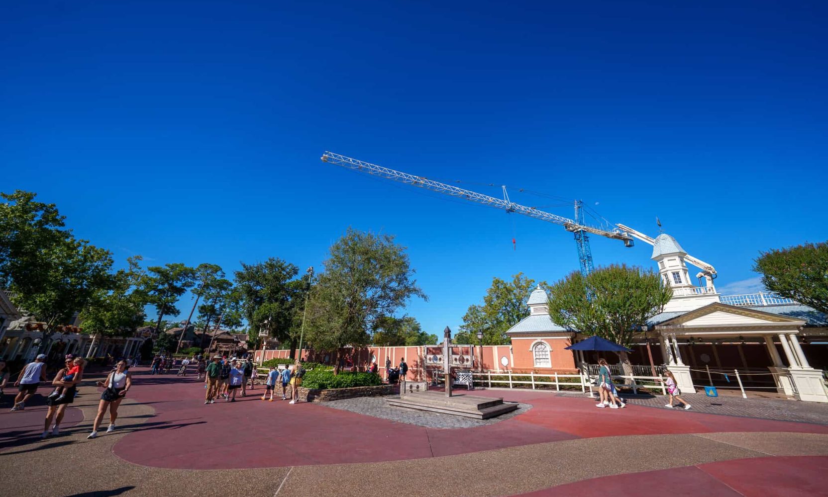 The Piston Peak Tower Crane Is Moving at Magic Kingdom, and Its Jib Appears to Reach Over a Liberty Square Walkway