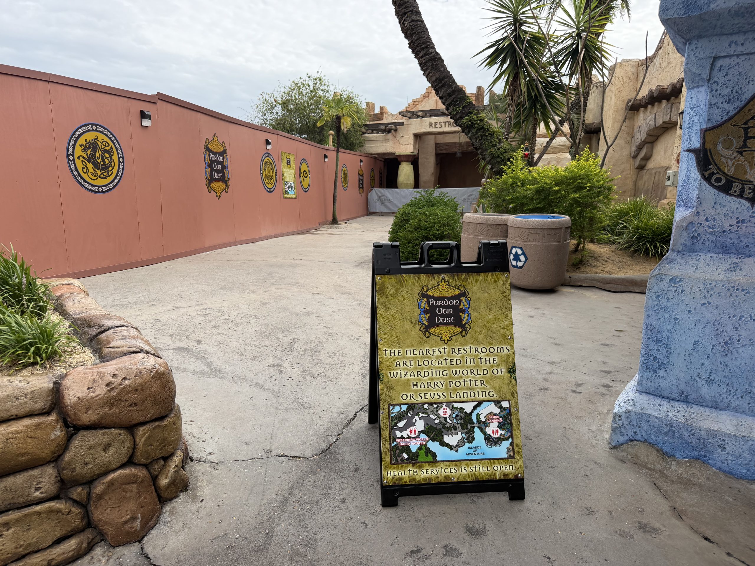 A sign directs guests to restrooms in other lands, noting Health Services is still open