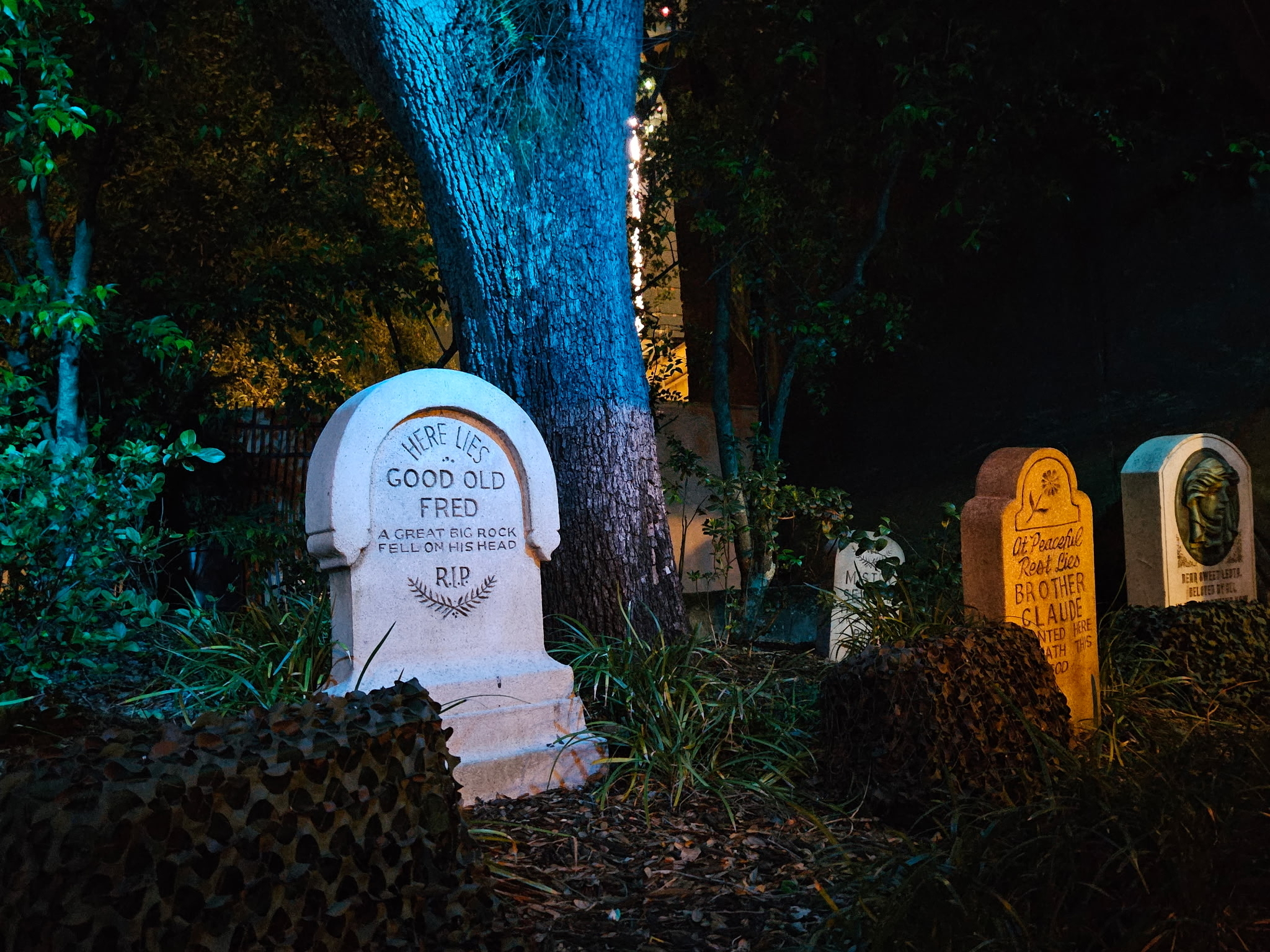 The neighboring cluster of graves near the Haunted Mansion queue, including Good Old Fred, Brother Claude, and Madame Leota