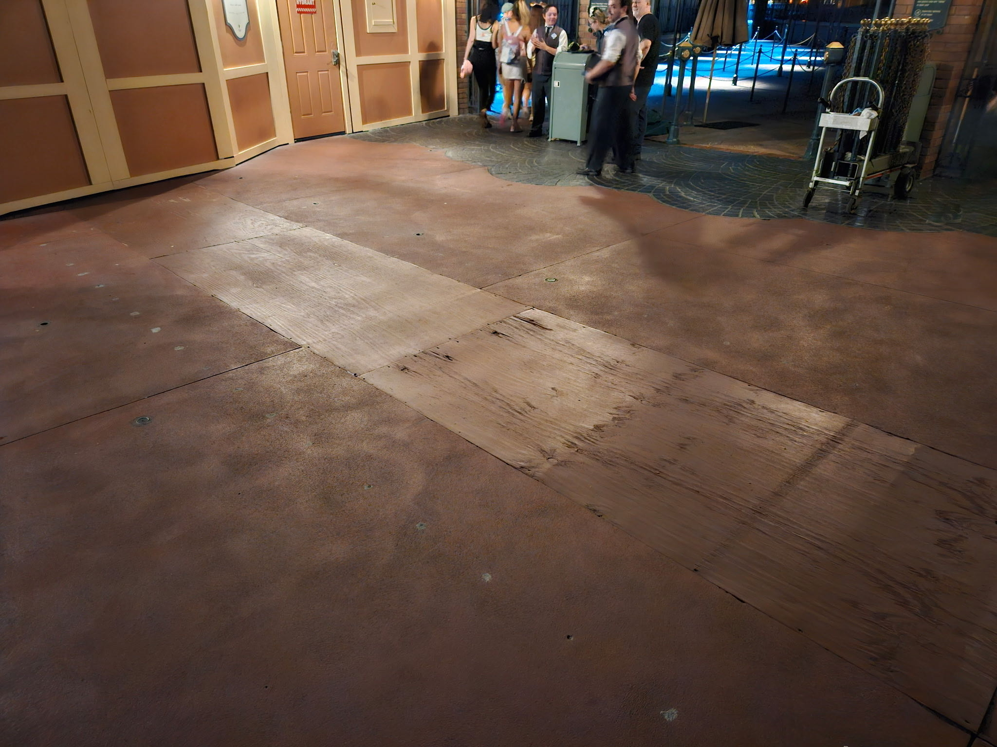 Wooden boards covering exposed walkway sections near the Haunted Mansion queue doors