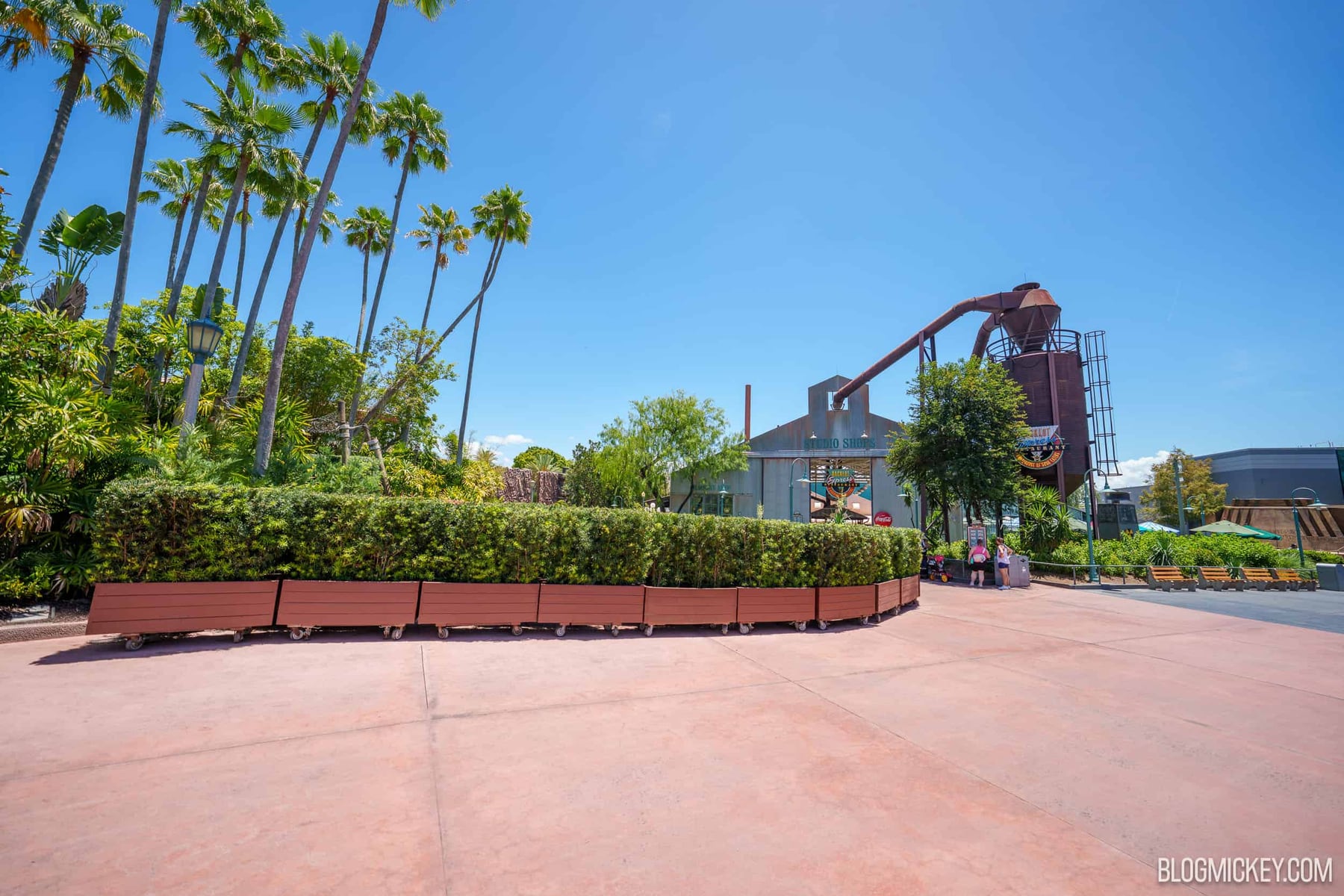 Rolling planters curve around a cleared dirt and concrete work site near Backlot Express at Disney's Hollywood Studios