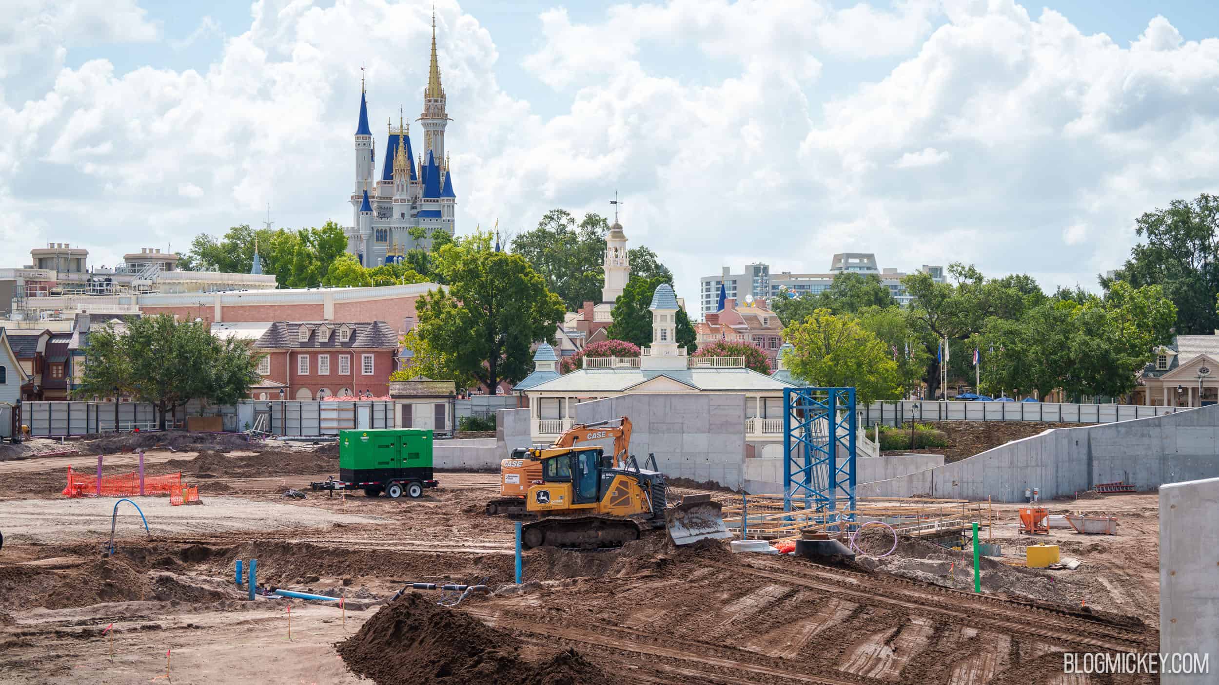 Construction at the Piston Peak National Park site at Magic Kingdom, with a crane structure and Cinderella Castle in the background