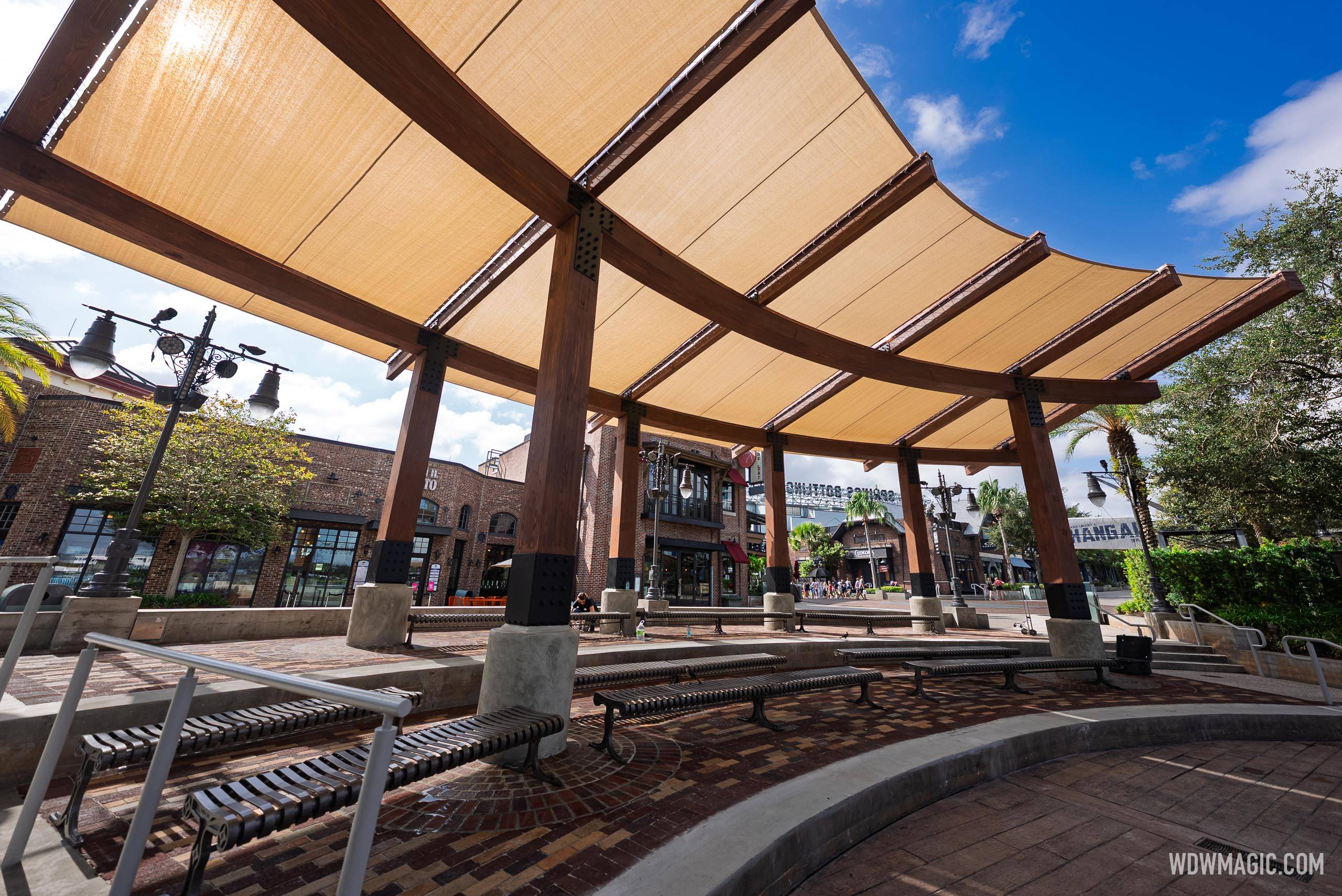 View from underneath the new Waterview Park canopy showing tan fabric panels on curved dark wood beams above the seating area