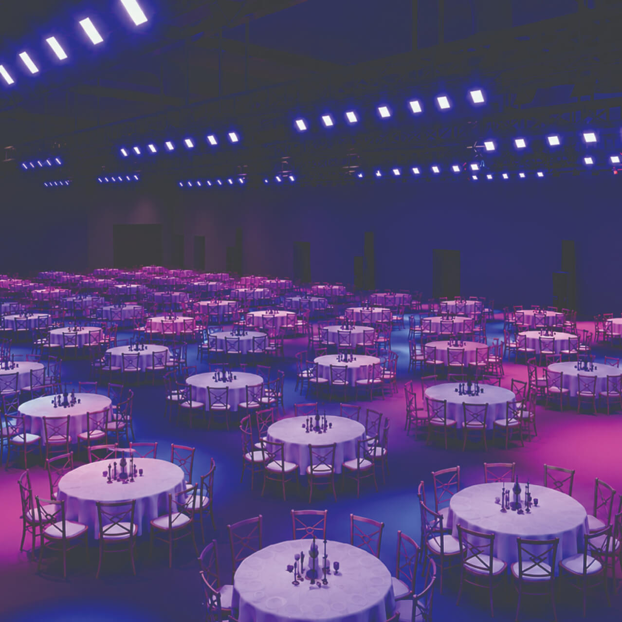 Rendering of a dark ballroom filled with dozens of round banquet tables with white cloths and cross-back chairs, washed in purple and blue light, with rows of light fixtures on an overhead grid