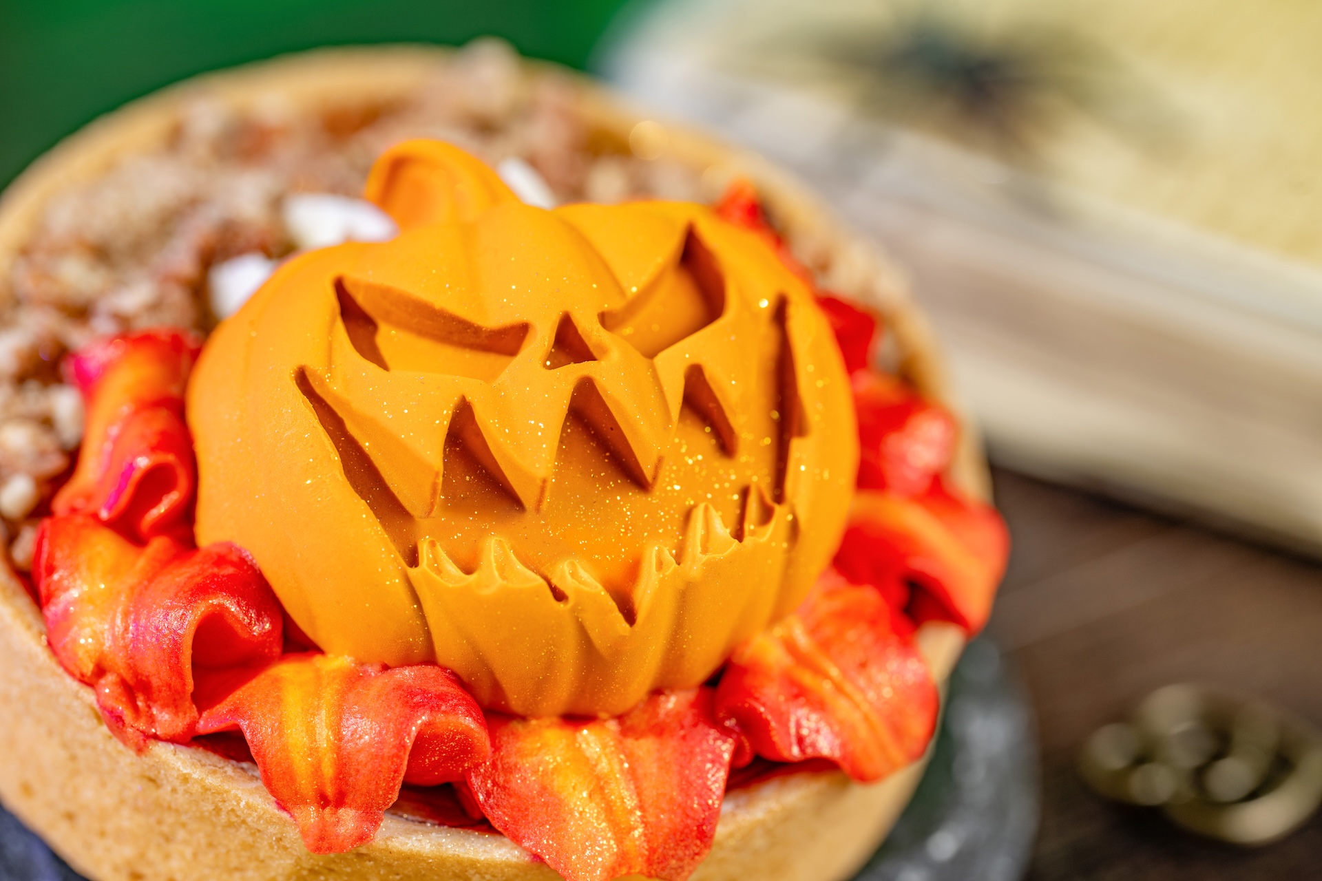 A pumpkin pie tart topped with swirls of whipped cheesecake, spiced caramel panna cotta and candied pecans, finished with orange marshmallow buttercream piped to look like flames.