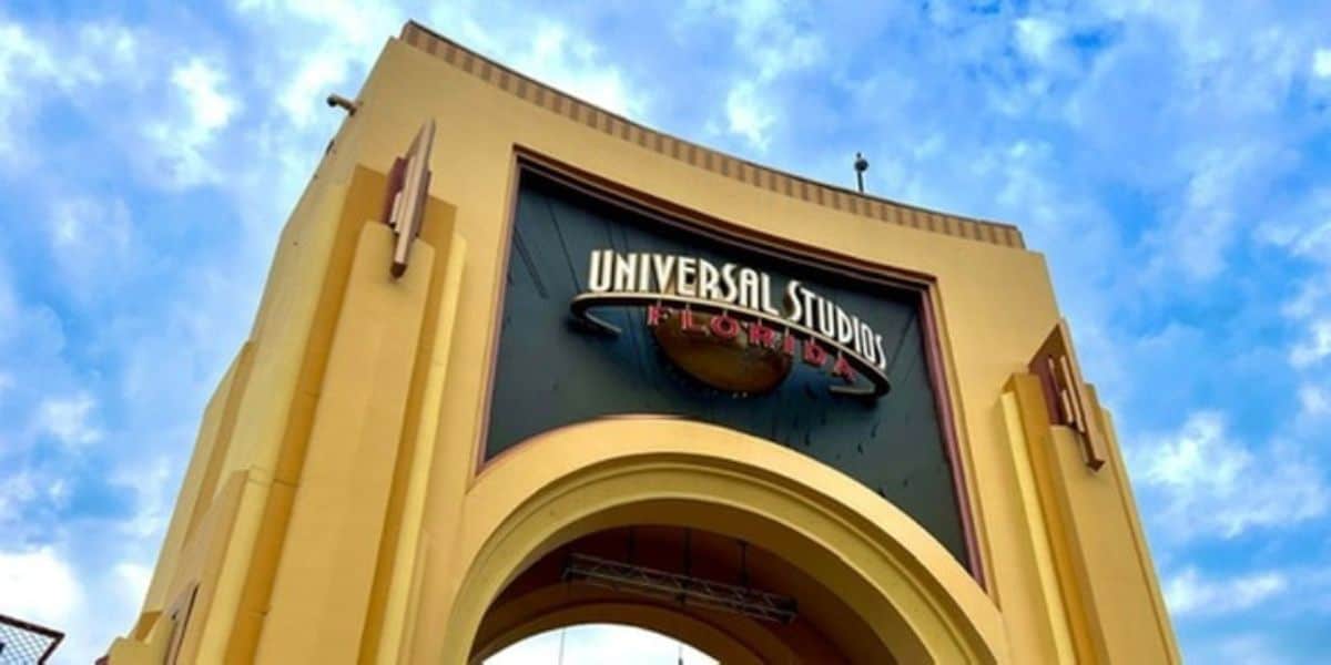Close-up of the Universal Studios Florida sign on the entrance arch against a blue sky
