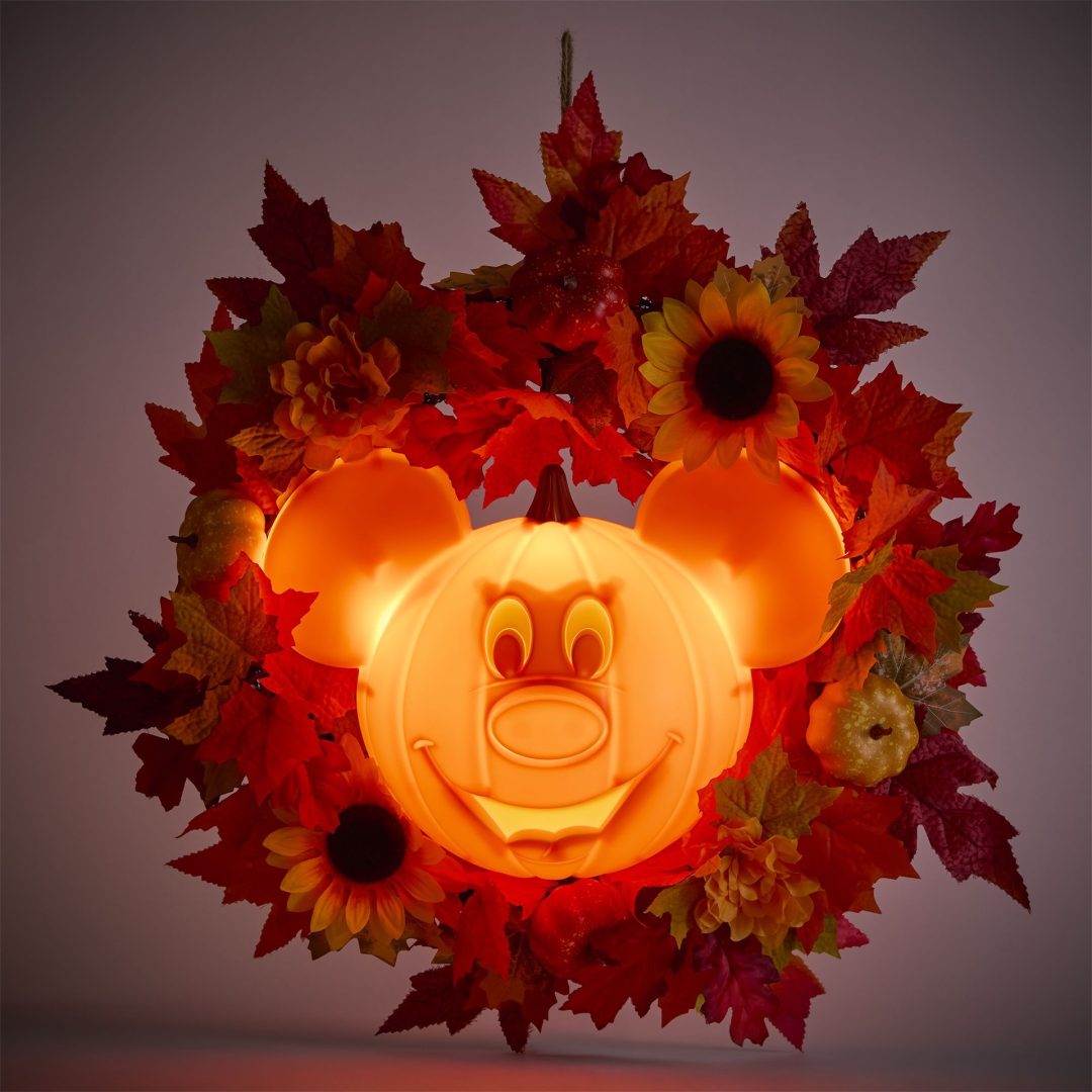 Light-up Mickey-shaped jack-o-lantern wreath surrounded by autumn leaves and sunflowers