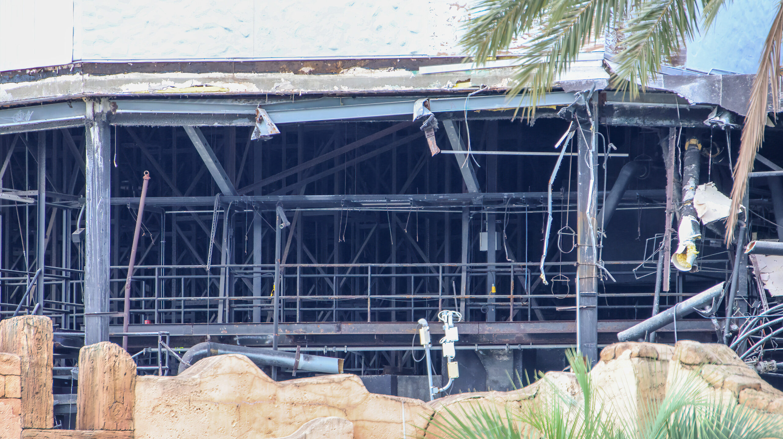 A close view of the exposed interior of Poseidon's Fury showing black steel framing, hanging cables, conduit and a large duct.