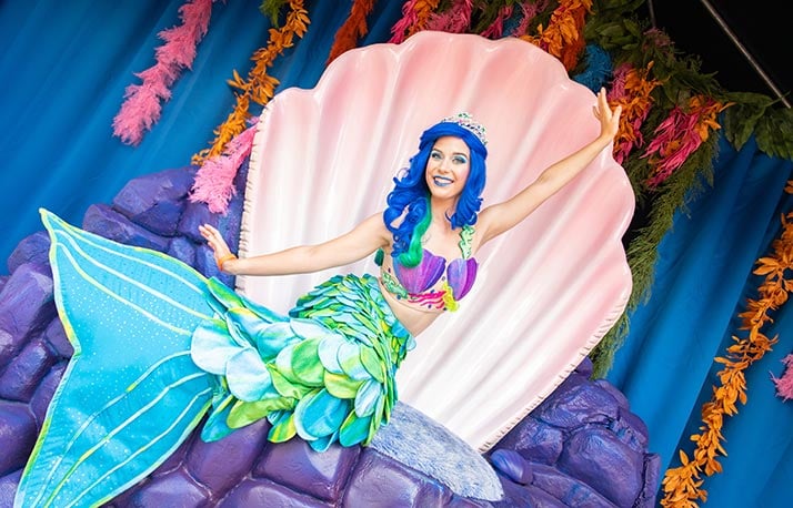 A costumed mermaid performer with a colorful tail greets guests at SeaWorld Orlando