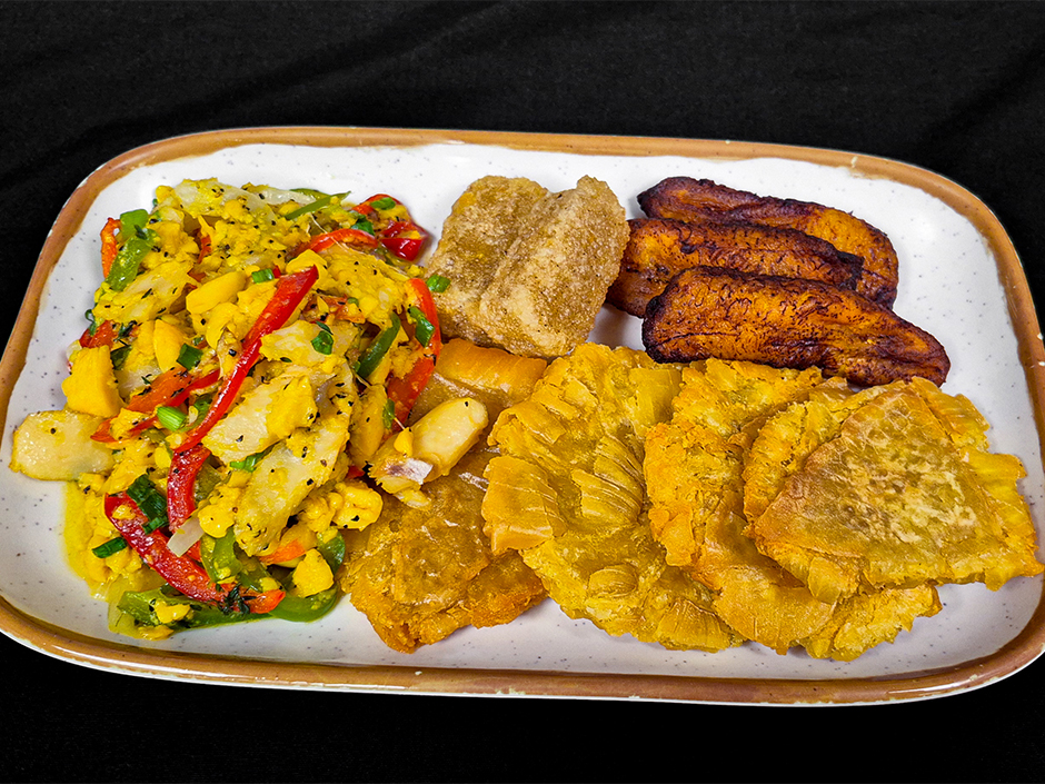 A plate of ackee and saltfish with roasted peppers, tomatoes and fried breadfruit
