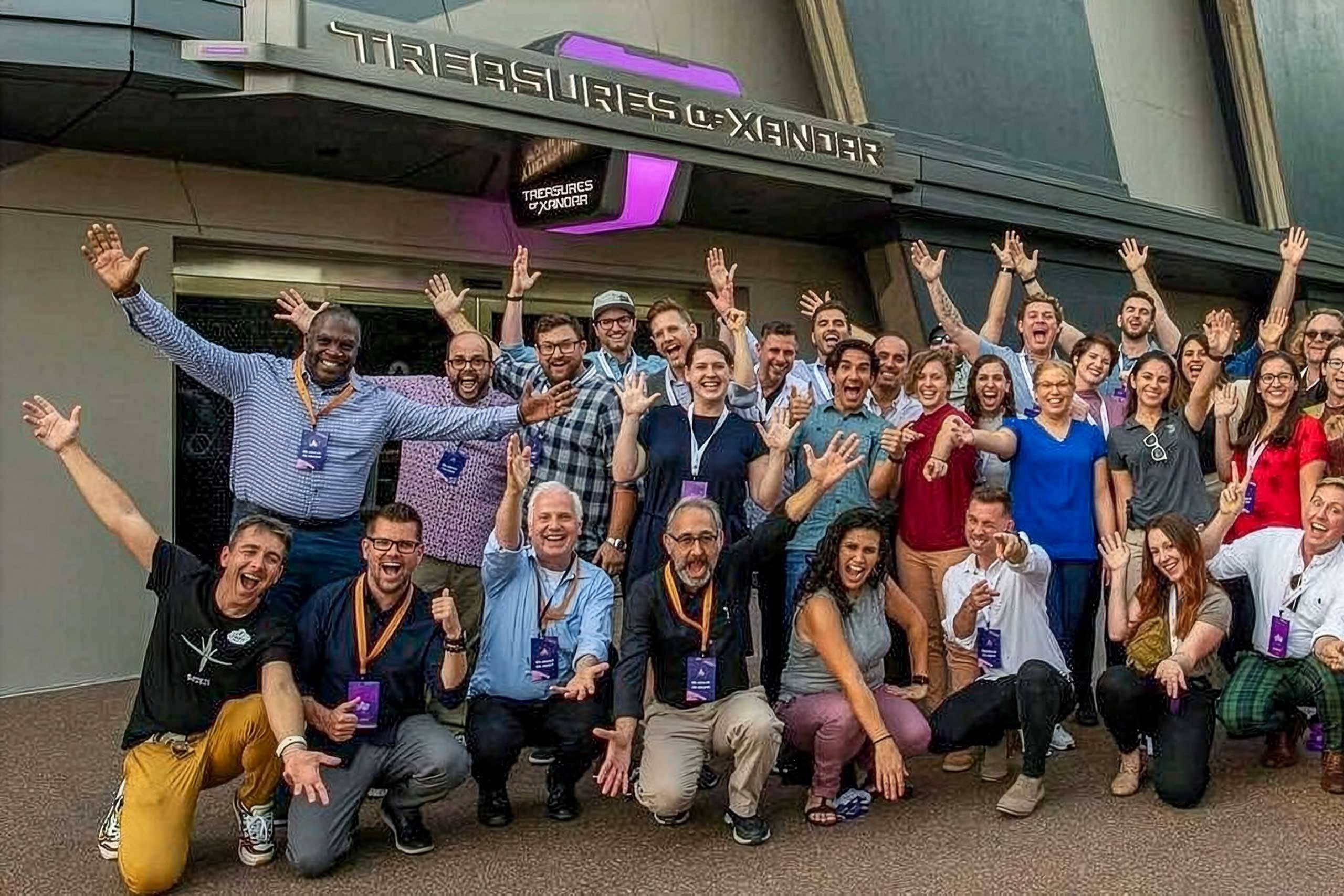 A large group cheering with their arms raised outside the Treasures of Xandar shop at the Cosmic Rewind opening