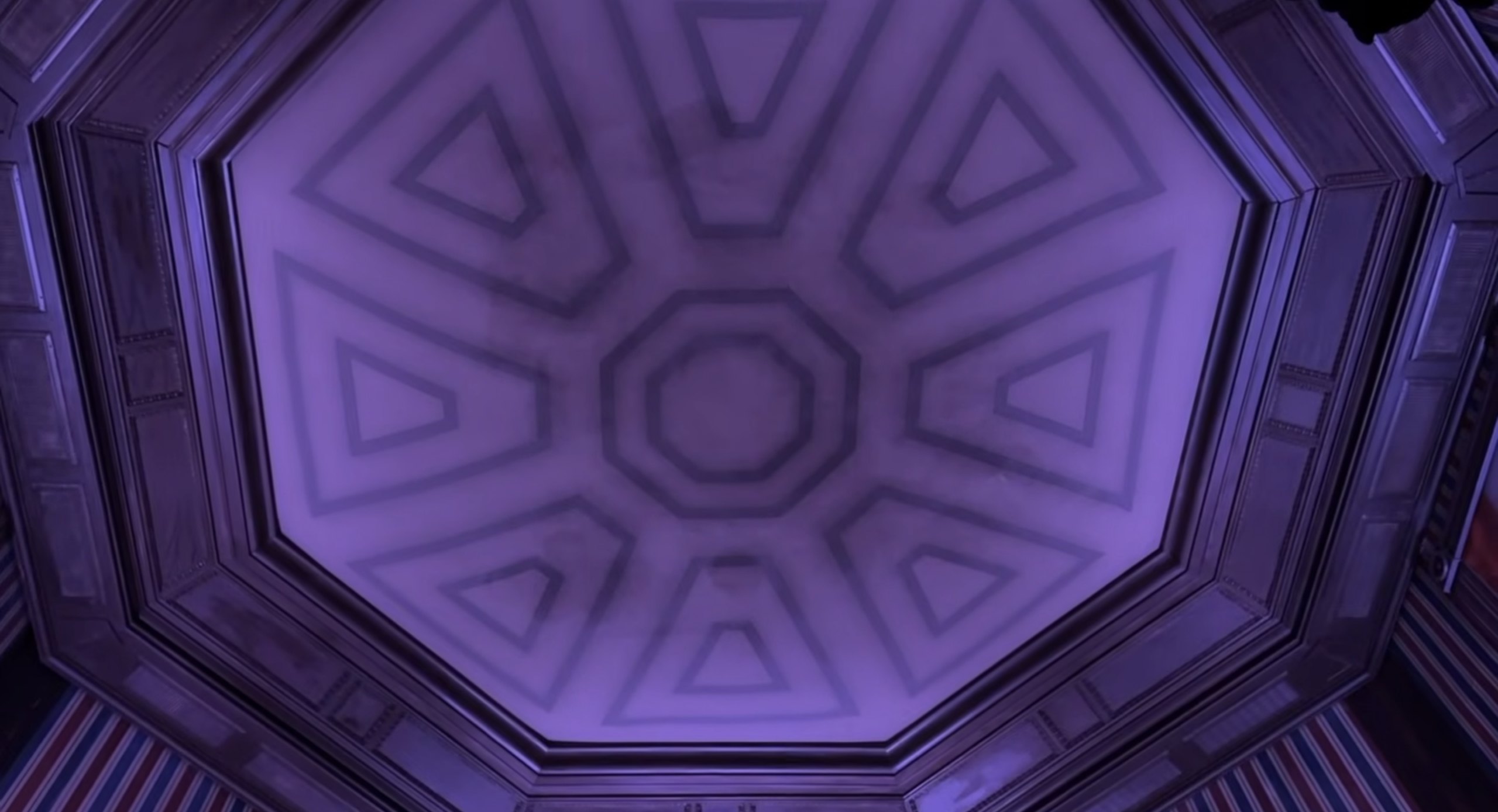 The old Stretching Room scrim lit in pale lavender, its triangle and octagon pattern flat and evenly toned with faint dark marks