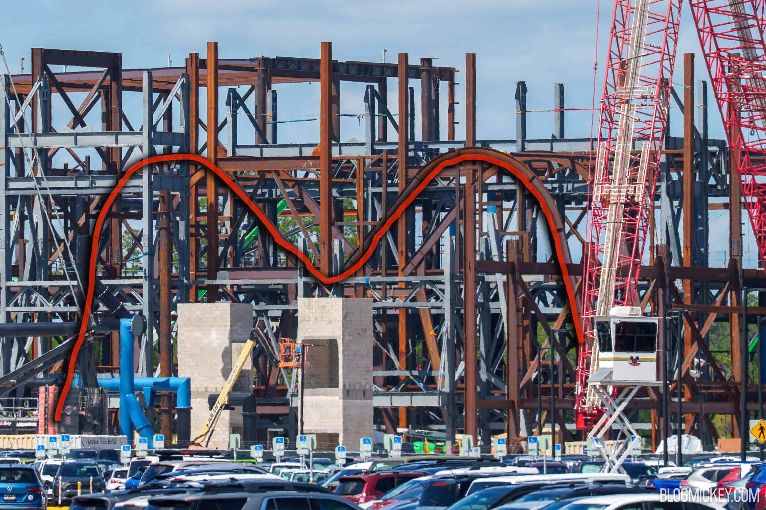 Construction steel for the Monsters, Inc. coaster show building with a red M traced over two arched ribs