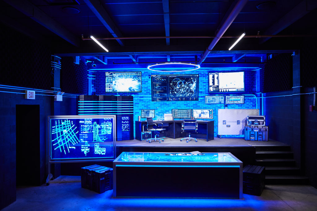 Tej's War Room from Fast and Furious Supercharged, a blue lit room with wall monitors and a glowing map table