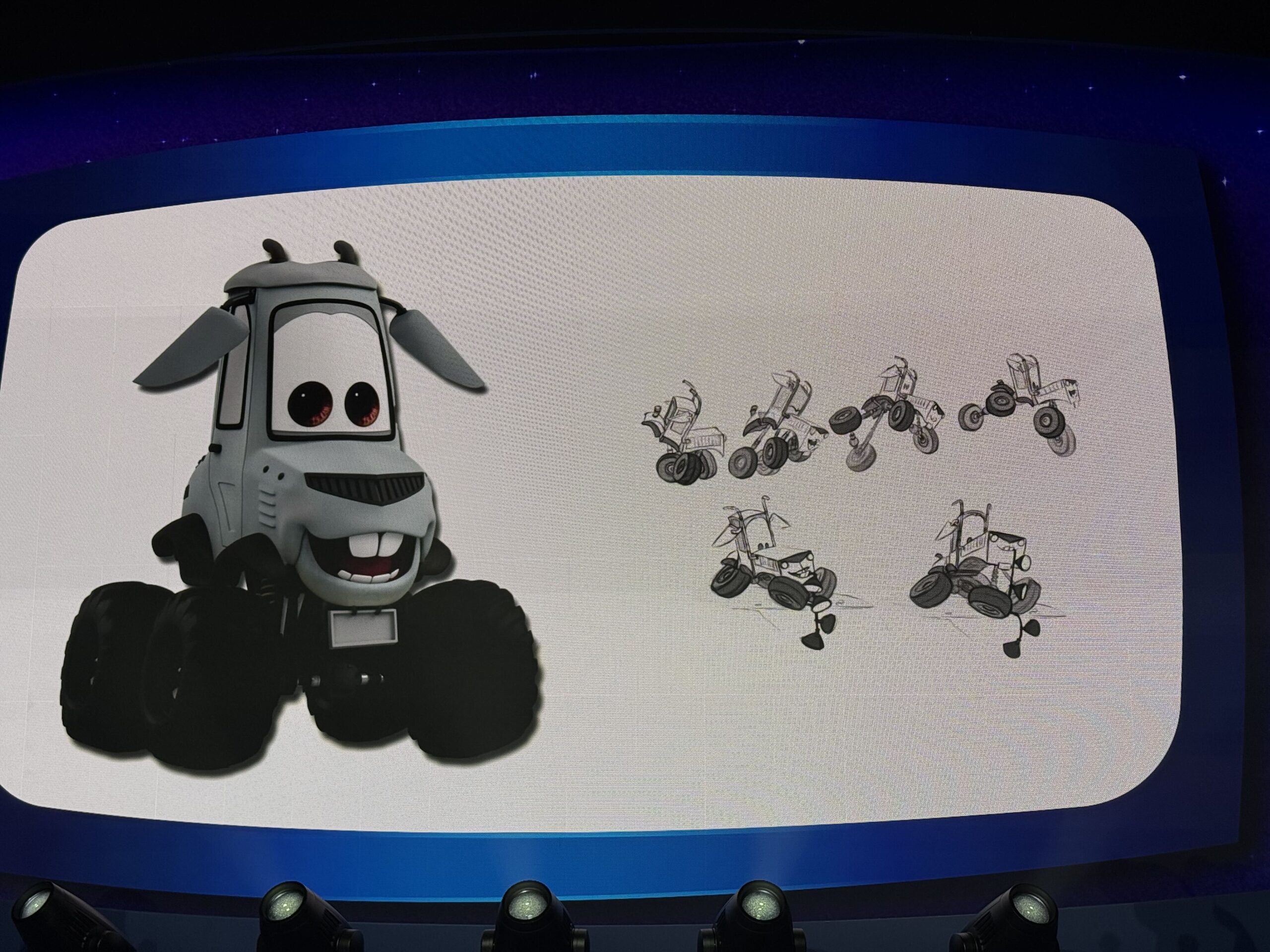A presentation slide showing a finished gray goat-like vehicle character with floppy ears and buck teeth beside six pencil concept sketches