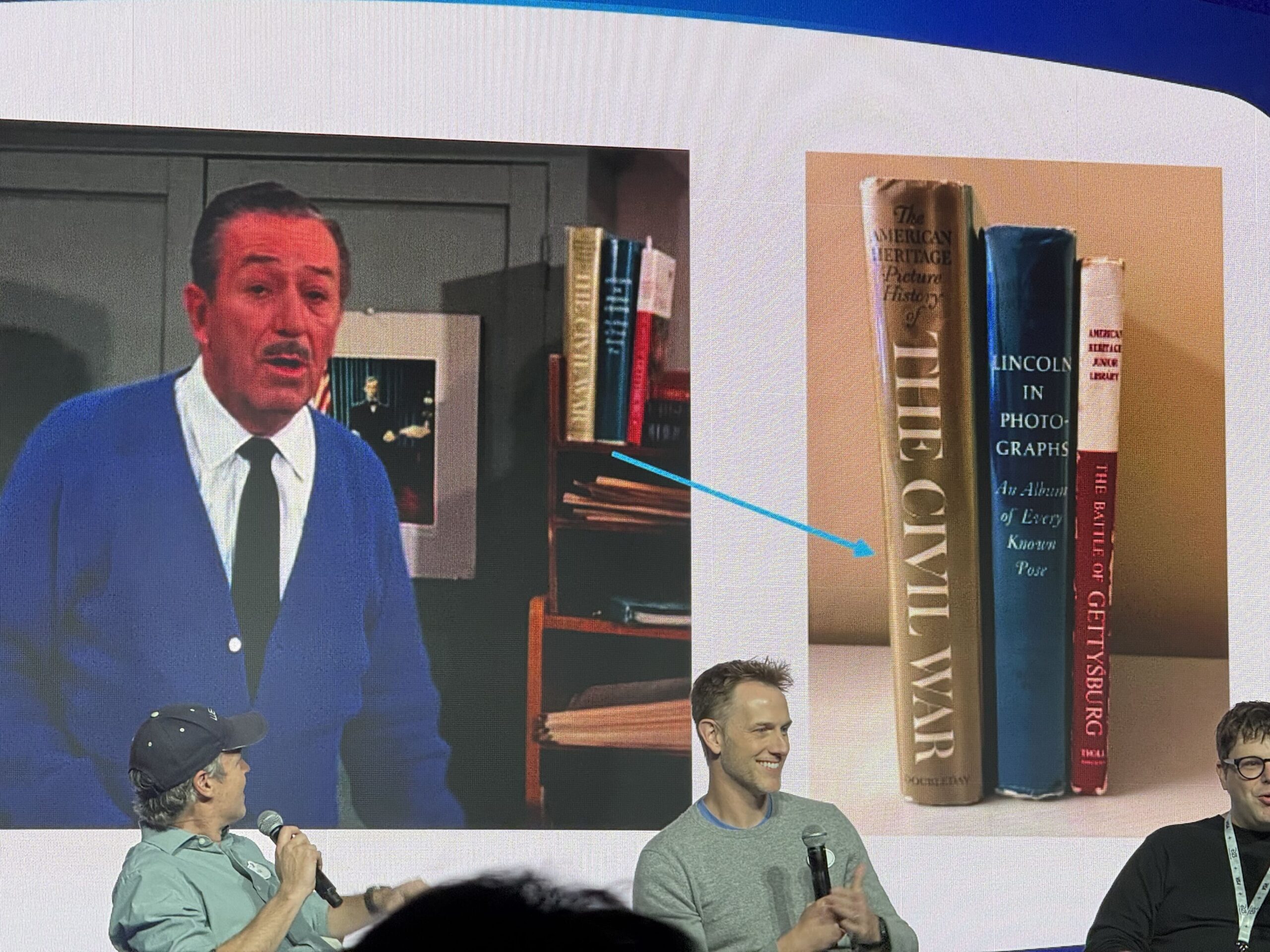 A presentation slide showing a frame of Walt Disney beside a bookshelf, next to a photograph of three sourced books standing upright with their spines visible