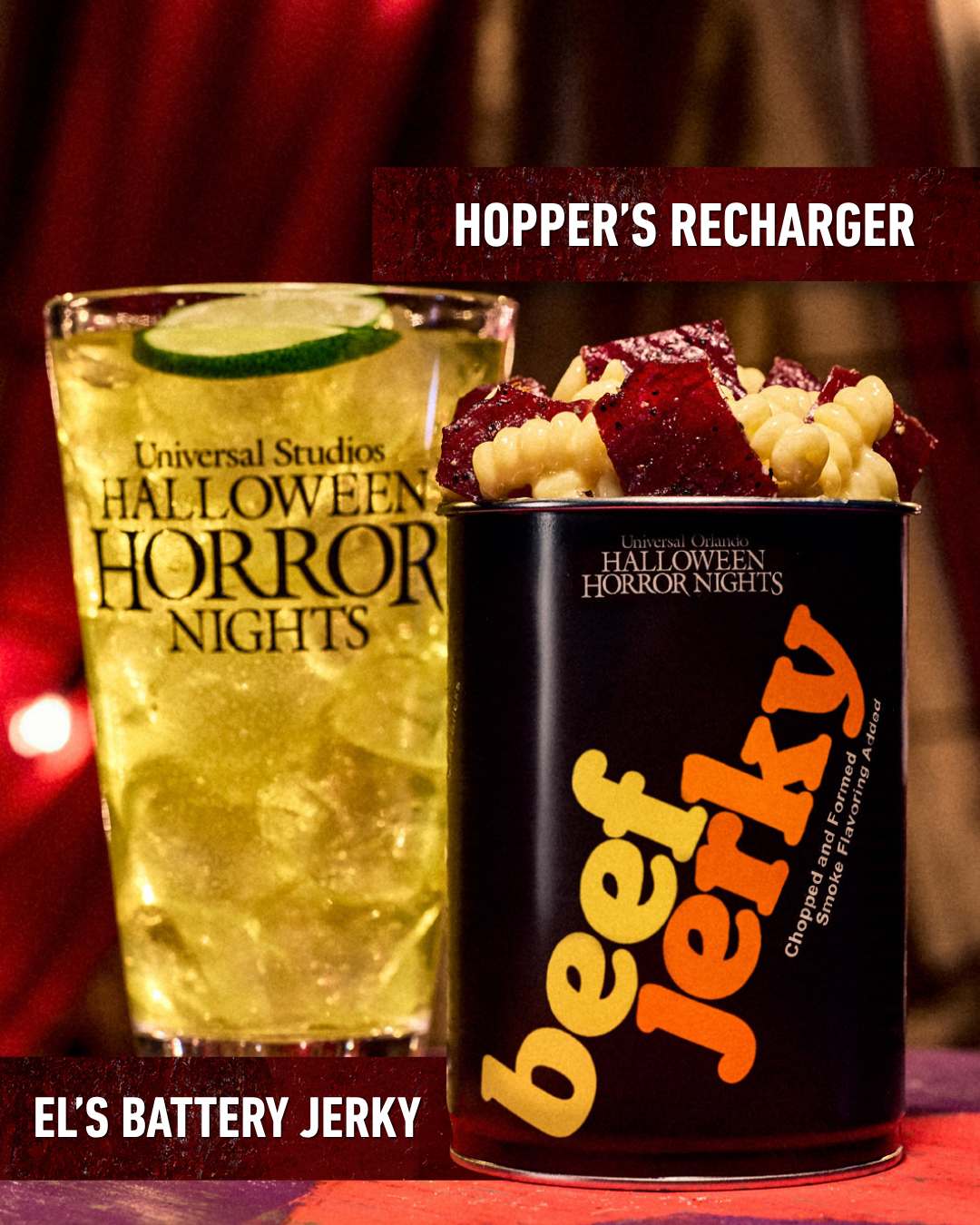 A pale yellow iced drink with a lime slice labeled Hopper's Recharger beside a black beef jerky can in orange and cream lettering labeled El's Battery Jerky, filled with cavatappi pasta and dark jerky pieces
