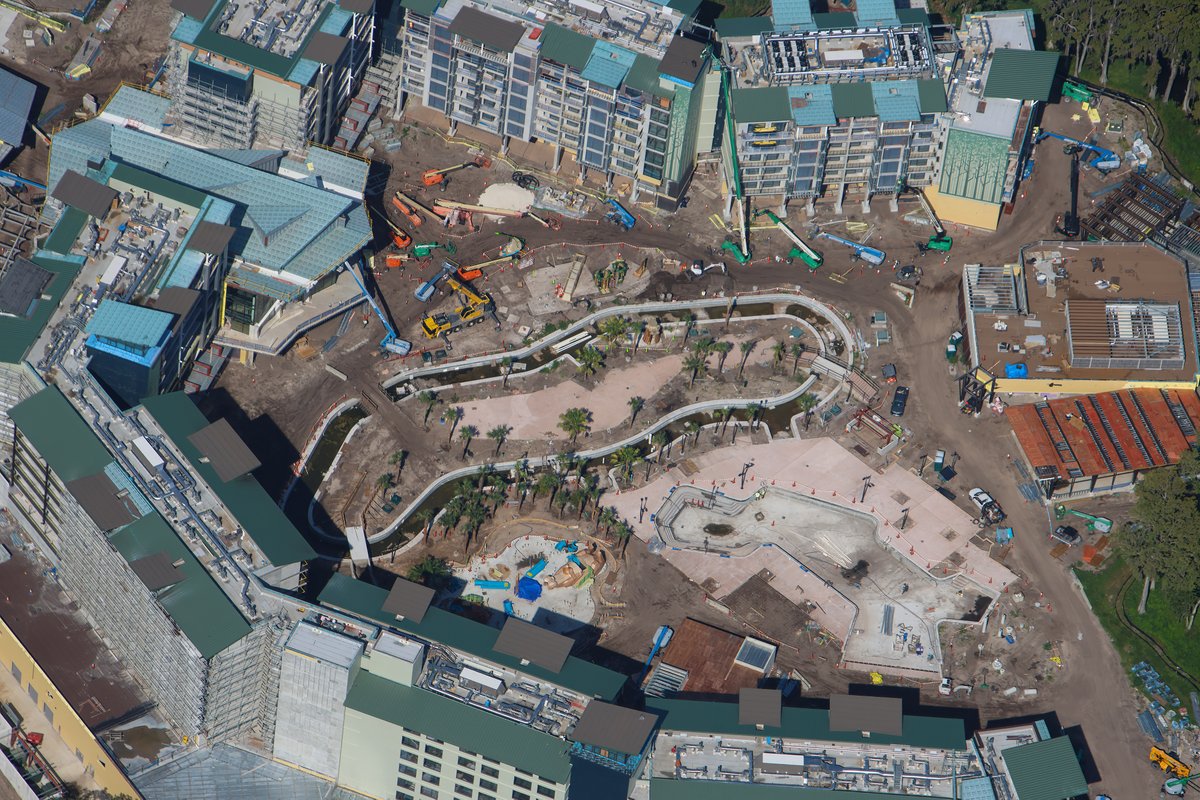 High overhead view of the Wetlands courtyard showing the looping lazy river channel, planted palms and the large feature pool basin