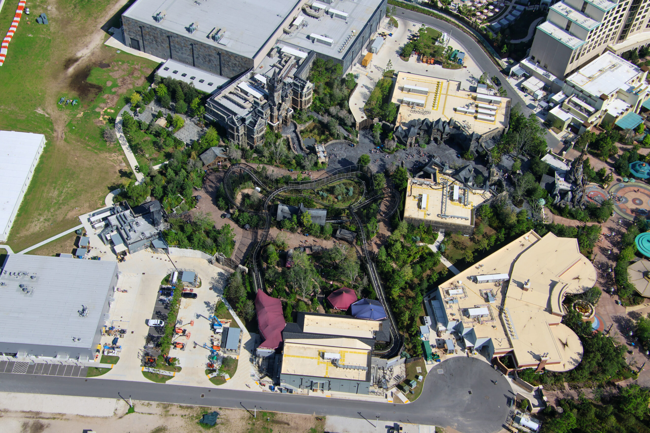 Wide aerial of the Dark Universe land showing Frankenstein Manor, the Curse of the Werewolf coaster track and the cleared ground at the edge