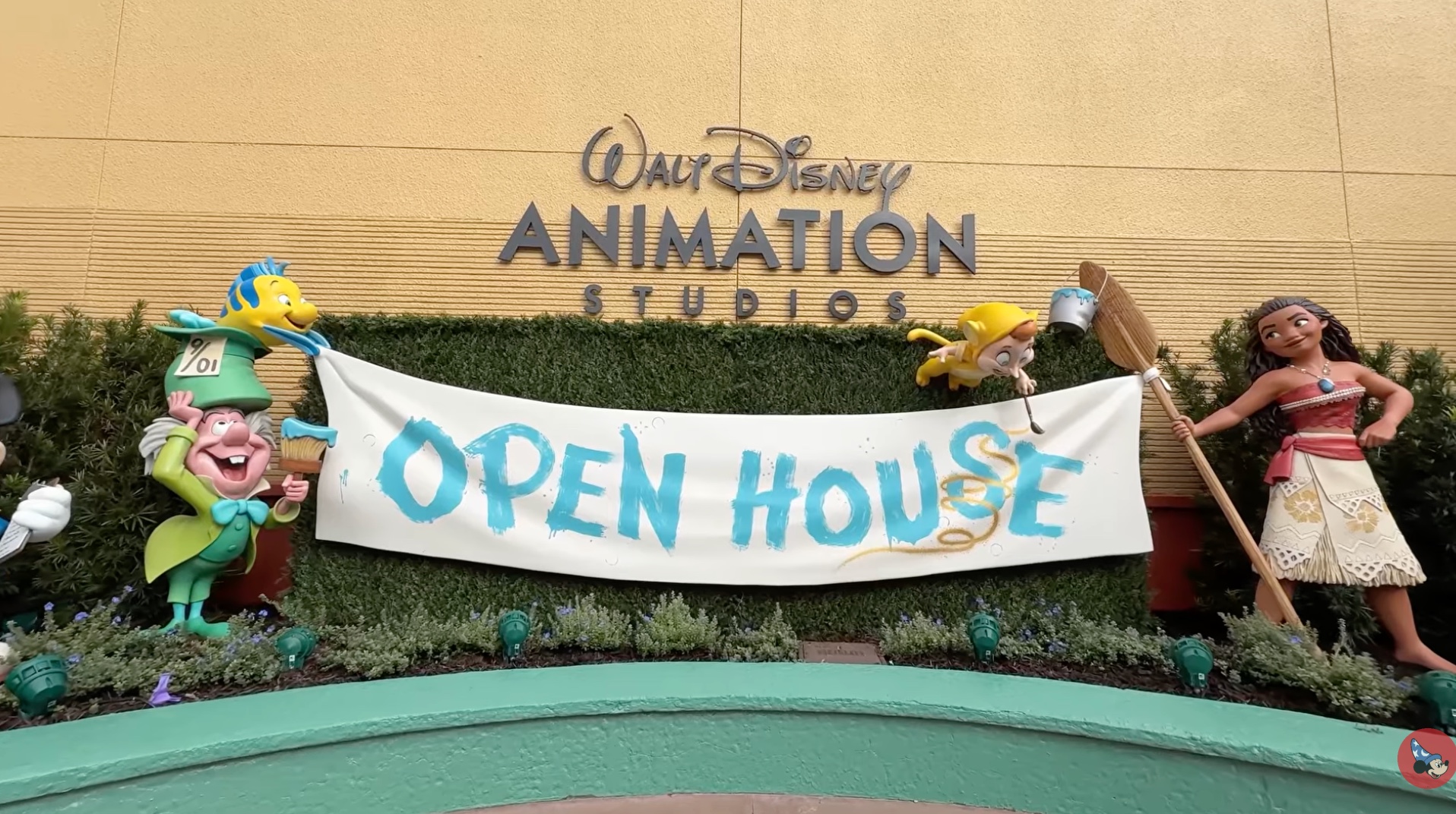 A white Open House banner strung between character statues below Walt Disney Animation Studios lettering on a yellow building