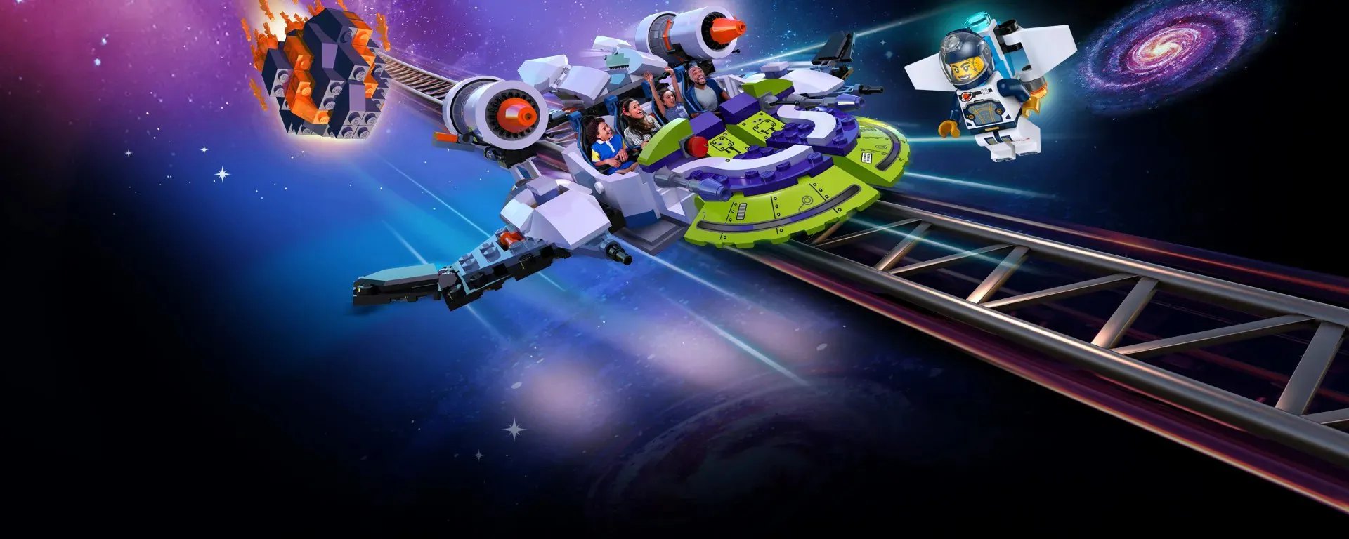 Illustrated key art for Galacticoaster showing a LEGO built spaceship coaster train carrying cheering riders through deep space beside a steel coaster track, with a LEGO meteor trailing orange flame at the upper left, an astronaut minifigure with a jetpack at the upper right and a spiral galaxy at the far right edge