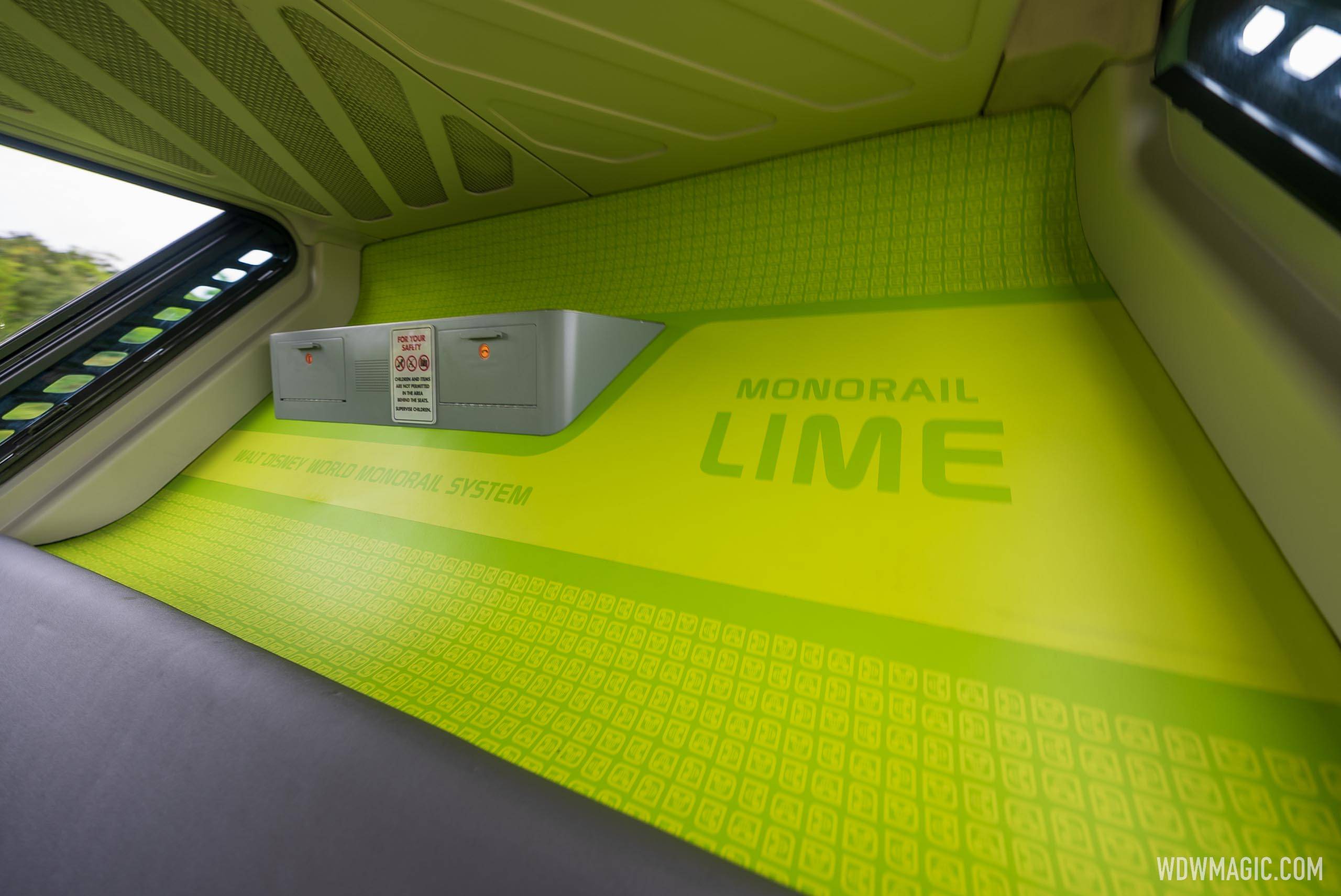 A close view of the lime green interior panel of a Disney World monorail cabin, showing the words Monorail Lime and Walt Disney World Monorail System alongside a small For Your Safety placard