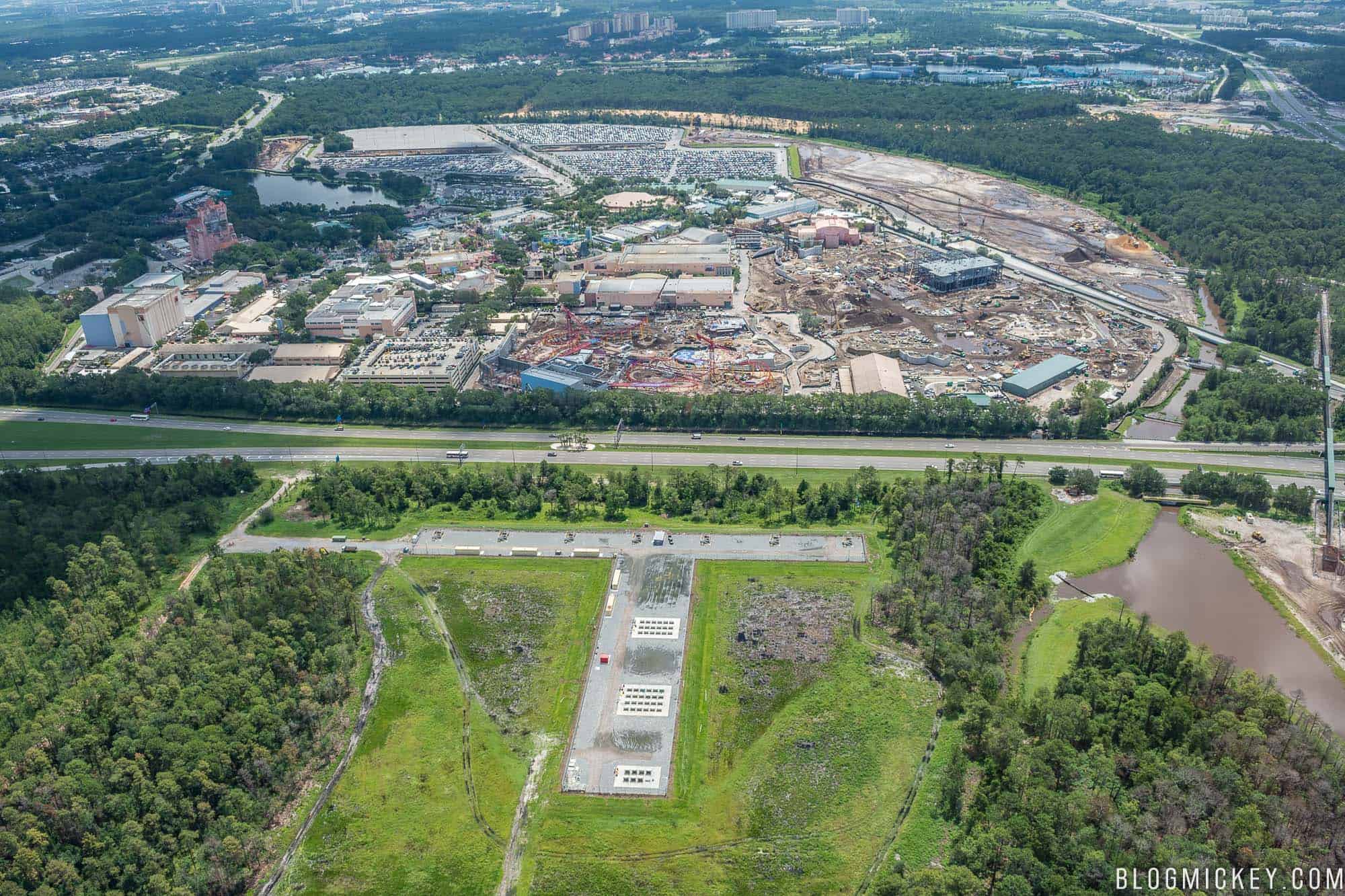 Aerial view of Disney's Hollywood Studios with the World Drive fireworks launch pads visible in a cleared field on the near side of the highway