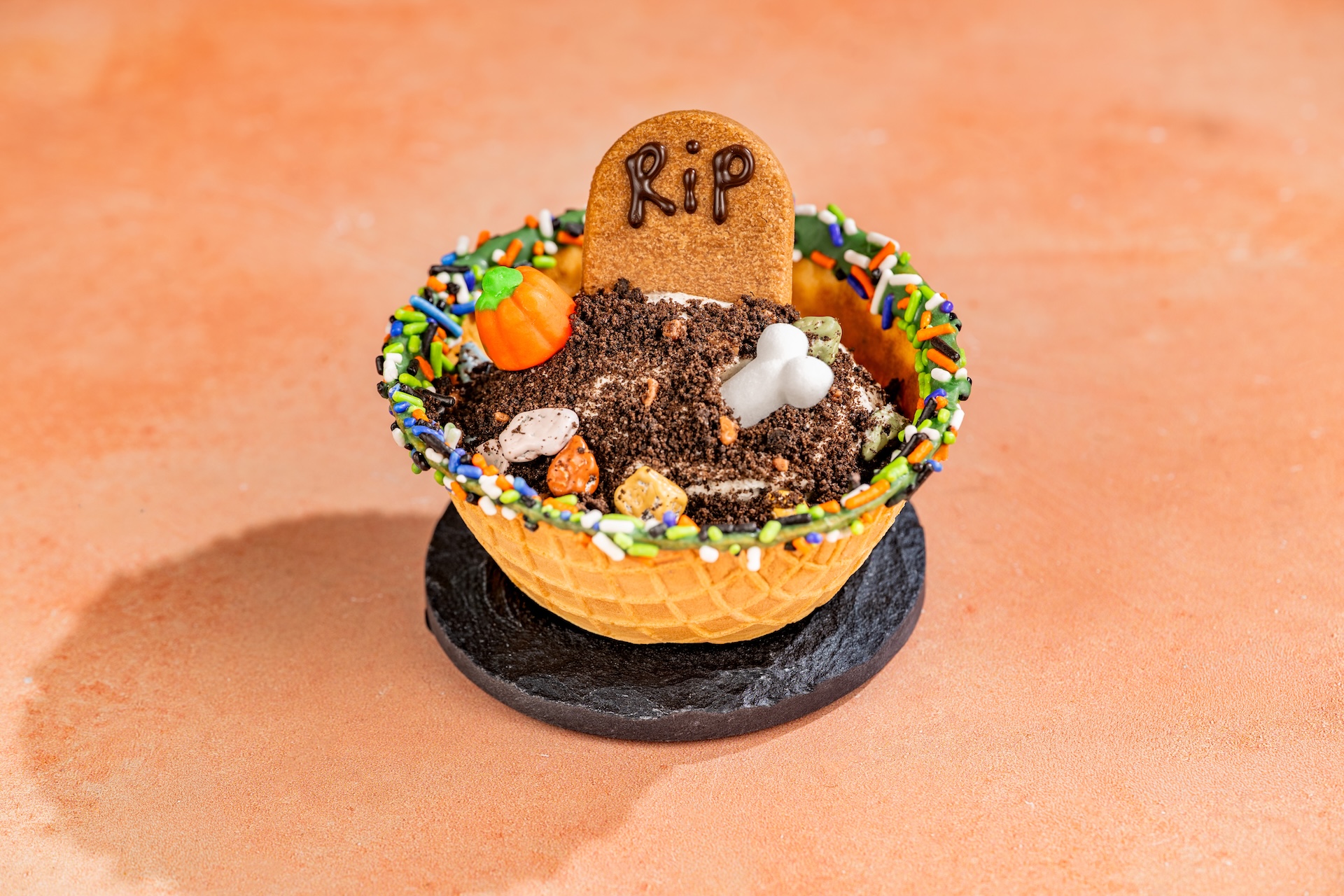 Boneyard Cookies and Scream Sundae in a waffle bowl with a sugar bone, pumpkin candy and Halloween sprinkles
