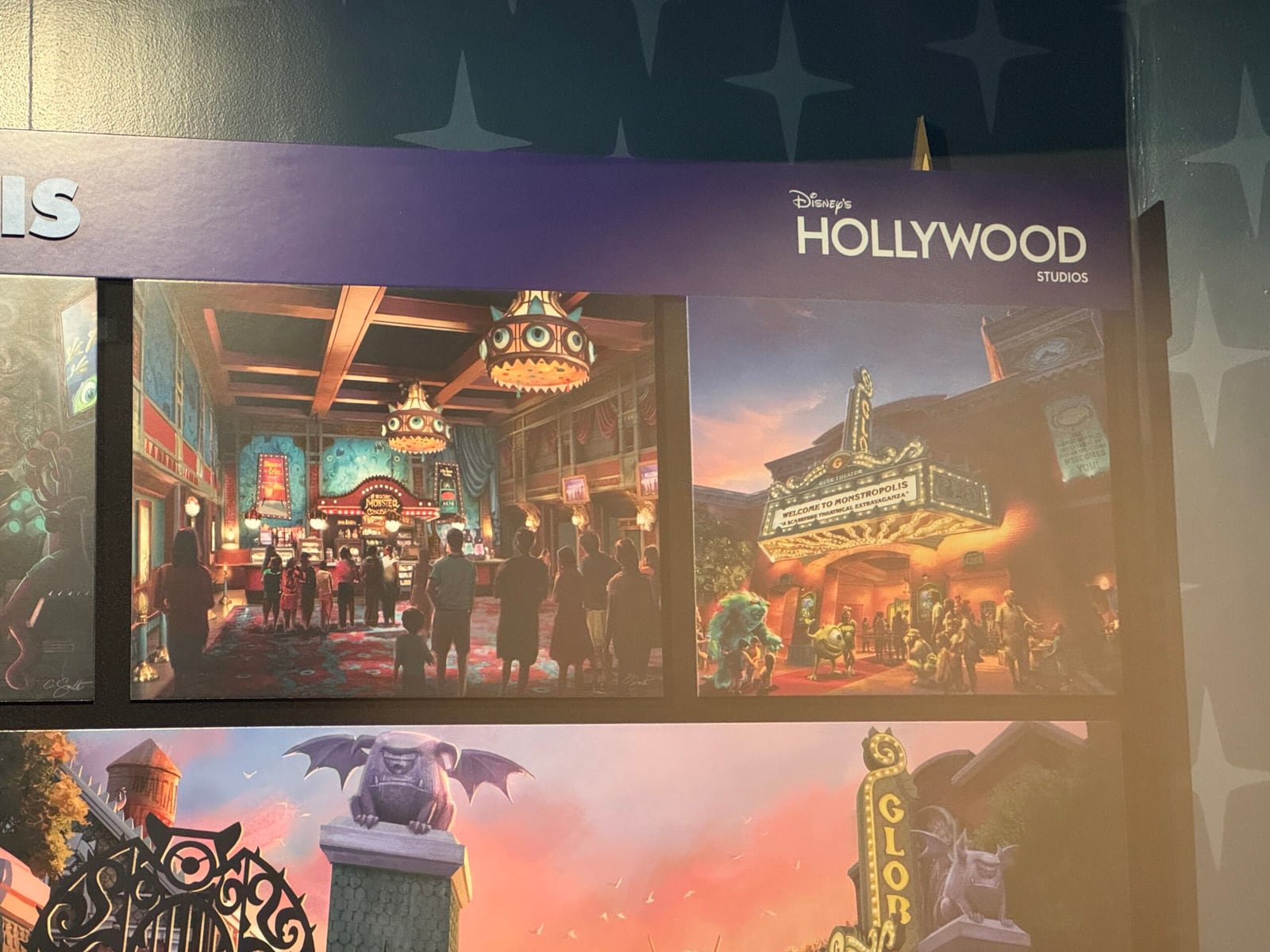 Two framed concept paintings under a purple Disney's Hollywood Studios banner: at left, a theater lobby with blue walls, red curtains, wooden ceiling beams, eyeball-covered chandeliers and guests lined up at a Monster Concessions stand; at right, the Glob Theater exterior at dusk with a lit marquee reading Welcome to Monstropolis, and Sulley and Mike out front