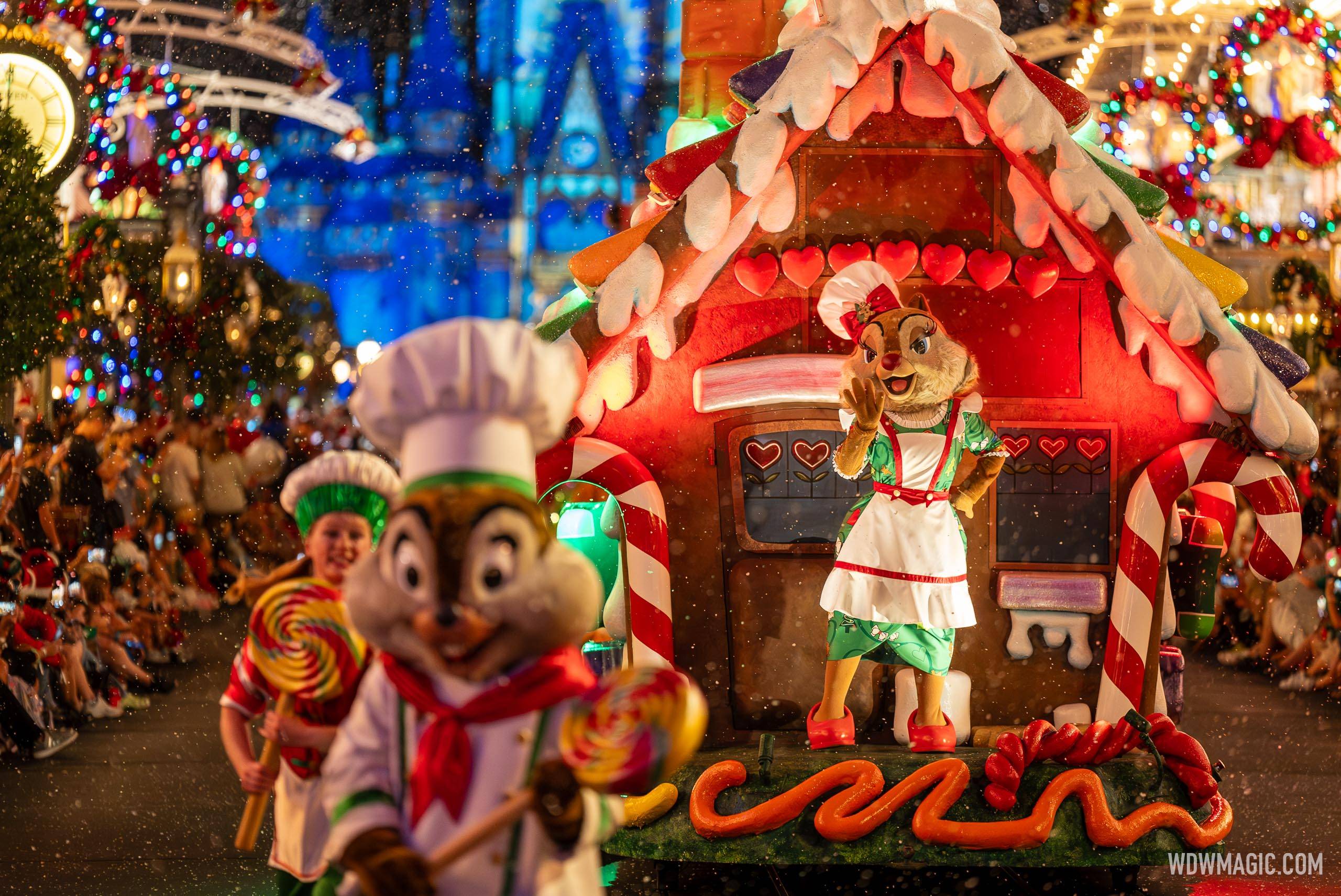 Clarice the chipmunk in a white baker's apron waving from a gingerbread house float covered in candy decorations, with a chipmunk in a chef's hat holding a giant lollipop in the foreground and the lit castle behind