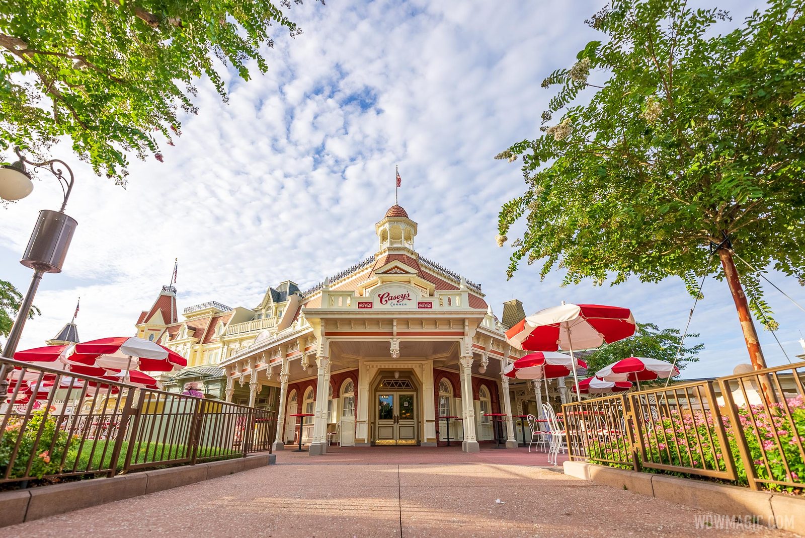 The Victorian-style Casey's Corner building on Main Street, U.S.A., with red and white umbrellas over its patio tables