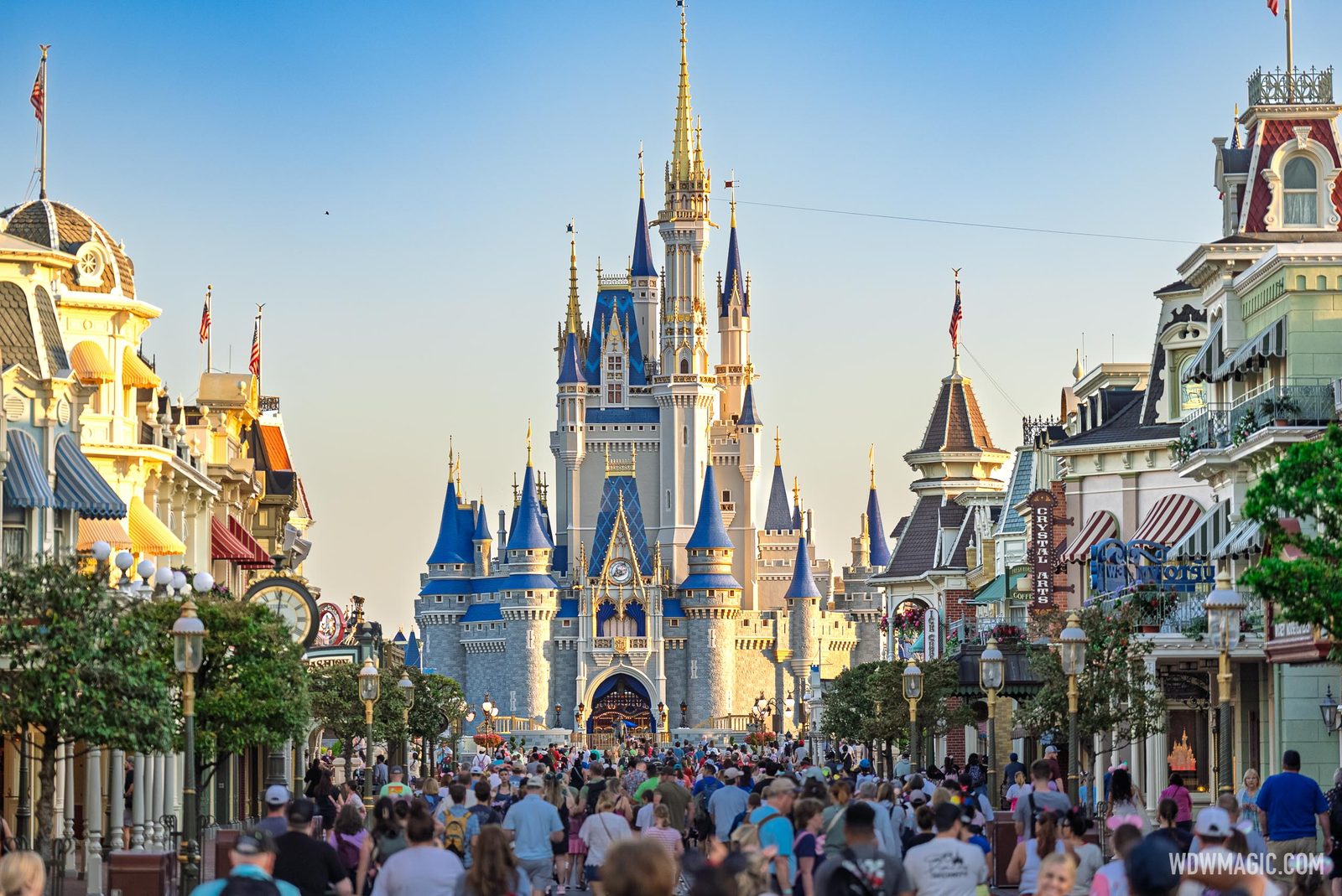 Crowds walking up Main Street, U.S.A. toward Cinderella Castle in the morning sun at Magic Kingdom