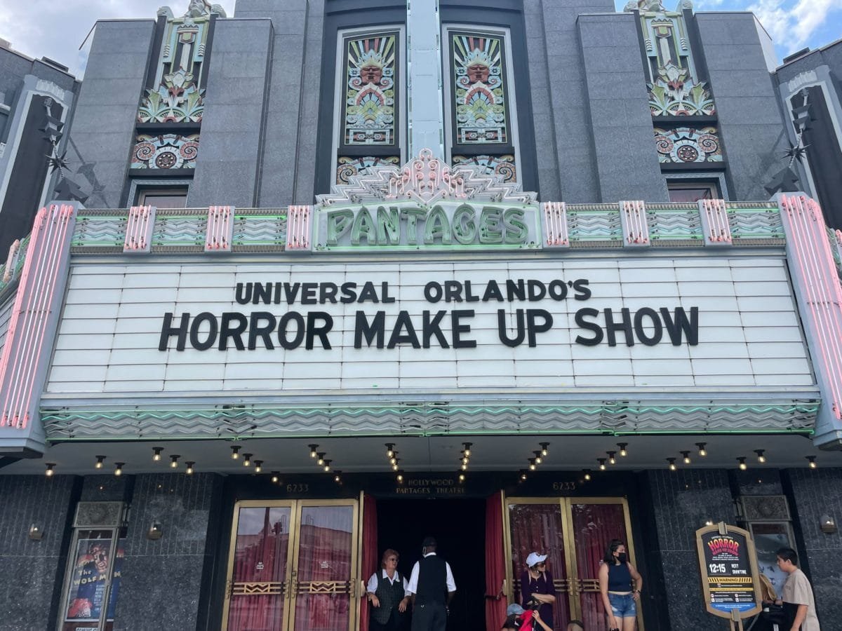 The Pantages theater marquee at Universal Studios Florida reading Universal Orlando's Horror Make Up Show, with guests at the gold entry doors