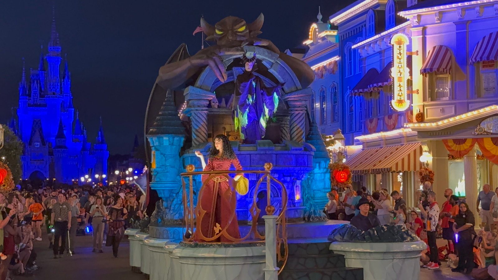 Mother Gothel and Maleficent on a villains float with a giant gargoyle in Mickey's Boo-To-You Halloween Parade on Main Street, U.S.A., as crowds watch