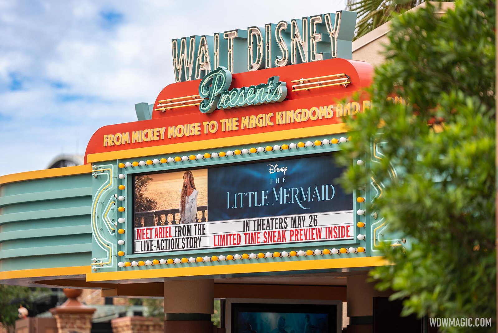 The Walt Disney Presents marquee at Hollywood Studios with teal neon lettering, a lightbulb-ringed sign showing an image of Ariel and The Little Mermaid title, reading Meet Ariel from the live-action story and In theaters May 26