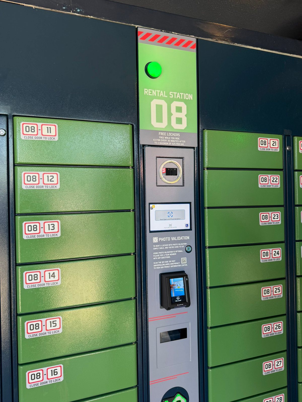 A green locker bank with hazard stripes and Rental Station 08, showing the posted rates and a photo validation camera, touchscreen and card reader