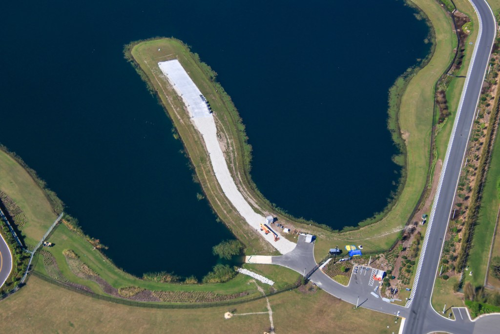 Aerial view of a newly built fireworks launch pad in a pond behind the Helios Grand Hotel at Epic Universe