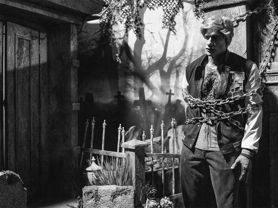 A black and white graveyard scene from The Grayscale Graveyard inside the H.R. Bloodengutz haunted house at Halloween Horror Nights 35.