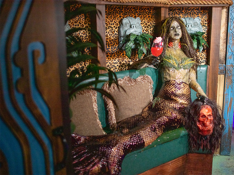 A mermaid figure in the Monster's Night Out tiki bar scene inside the H.R. Bloodengutz haunted house at Halloween Horror Nights 35.