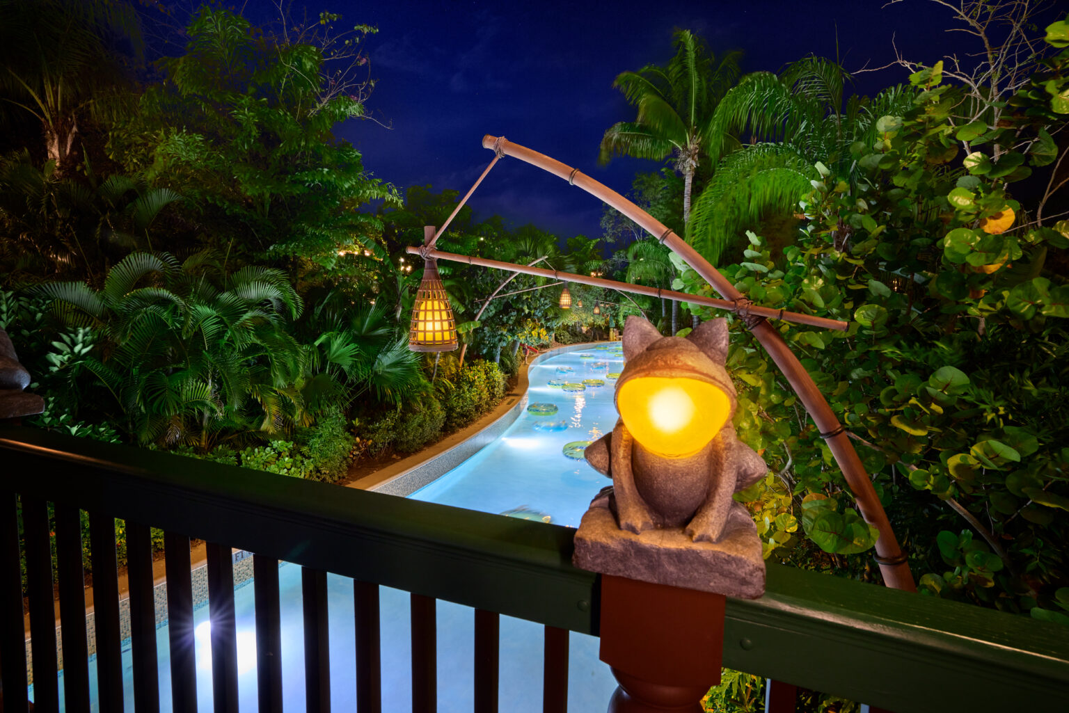 Guests gather on Waturi Beach at Volcano Bay Nights for the DJ-led Beach Bash with Krakatau in the background.